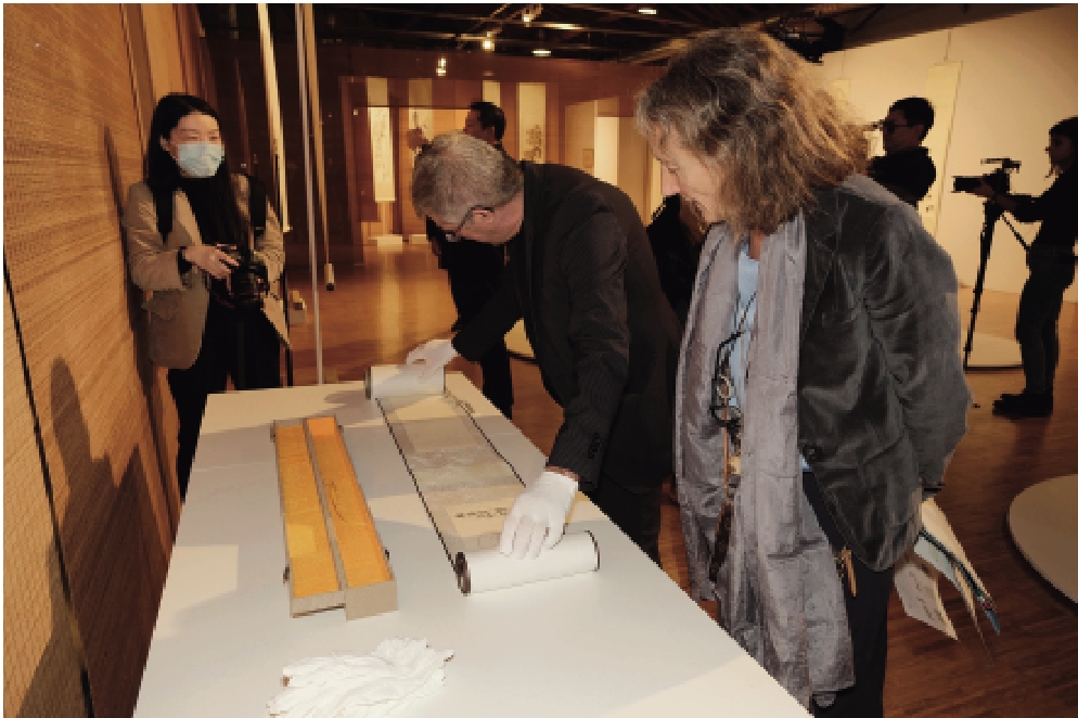  “不喜平庸——齐白石的艺术世界”展览现场，意大利观众展开手卷，在咫尺之间感受中国艺术的意境悠远。